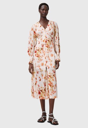 Bloemen midi-jurk met lange pofmouwen, V-hals en een voorkant met split. Heeft een lichte, gestructureerde stof met oranje en roze bloemenpatronen.