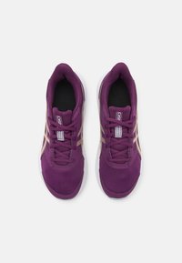 Une paire de chaussures de course Asics violettes avec des logos beiges, des semelles blanches et des semelles intérieures noires, vues du dessus sur un fond blanc.