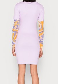 Rifle krátký rukáv v světle levandulové barvě s vzorovanými dlouhými rukávy v oranžových, žlutých a fialových spirálách. Slim fit, délka ke kolenům.