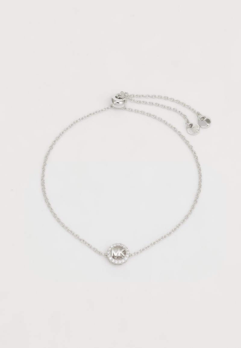 Bracciale in argento con ciondolo circolare al centro, con la scritta "MK" circondata da un anello di piccole pietre trasparenti. Chiusura regolabile.