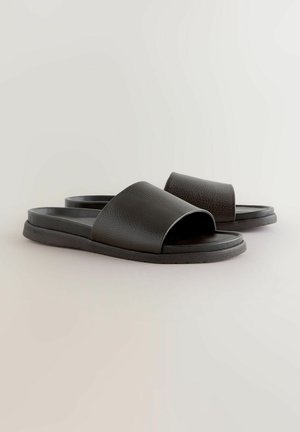 Zwarte slidesandalen met een bovenwerk van gestructureerd leer, open teen en een gladde rubberen zool. Kenmerken een minimalistisch ontwerp zonder versieringen.