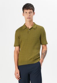 Kortærmet polo-shirt i olivengrøn. Har et tekstureret ribbet design, kravehals og placket med tre knapper.