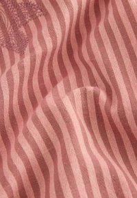 Randig tyg i nyanser av rosa, med ett texturerat mönster av vågiga linjer. Materialet verkar mjukt med en slät yta.