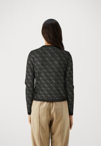 Black sweater with diamond pattern, ribbed cuffs and hem, made from textured material. Back view with fitted design and narrow neckline.