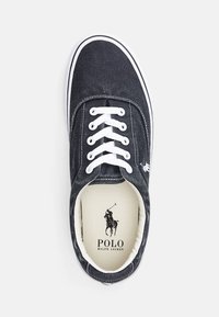 Granatowy tenisówka ze skóry płóciennej z białymi sznurowadłami, gumową podeszwą i kontrastową białą krawędzią. Na wkładce znajduje się logo Polo.