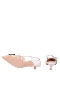 Scarpe con punta affilata e finitura in vernice rosa chiaro. Presentano un accento intrecciato beige sul tallone e cinturini sottili alla caviglia. Suola leggermente rialzata.