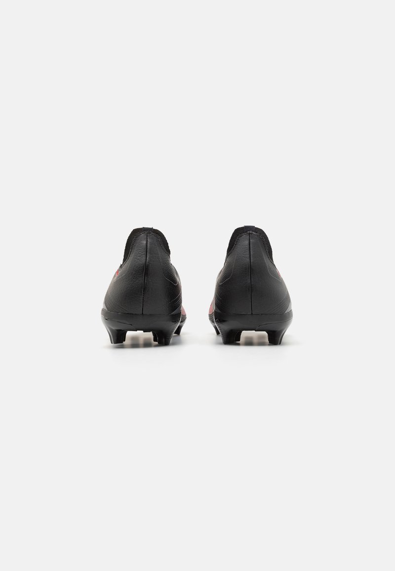 Botas de fútbol negras con un diseño bajo, parte superior de cuero texturizado y acentos rojos. Suela con múltiples tacos para tracción en diversas superficies.