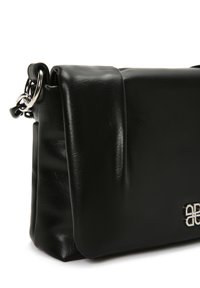 Borsa nera in ecopelle con una superficie liscia, forma rettangolare e un accento in catena argentata. Il design include una patta anteriore piegata.