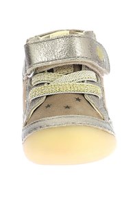 Zapato para niño pequeño de cuero metálico plateado con tira de Velcro, cordones elásticos y suela beige; cuenta con pequeñas estrellas negras en el lateral.