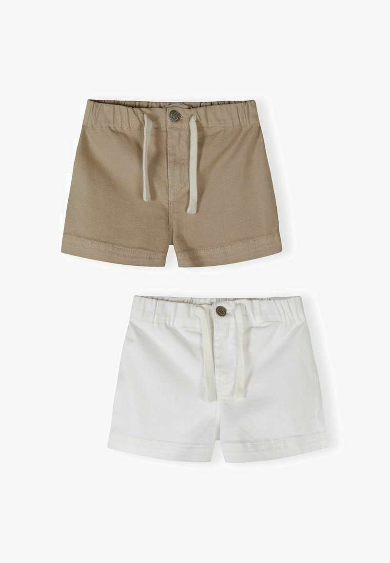 Deux paires de shorts pour tout-petit, une beige et une blanche, toutes deux avec des ceintures élastiques, des fermetures à boutons et des cordons de serrage.