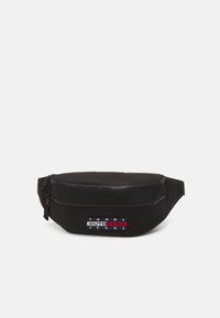 Svart nylon mageveske med en glidelås-lomme foran, med et rektangul�ært logodesign i hvitt og rødt. Kompakt, avrundet design med justerbar stropp.