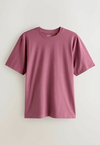 T-shirt à manches courtes et col rond de couleur rose poussière. Fabriqué en tissu doux avec une texture lisse et une coupe décontractée. Étiquette visible au niveau de l'encolure.
