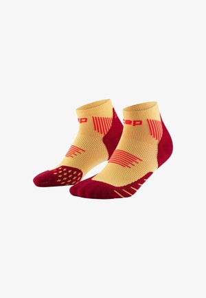 Short athletic socks in yellow with red accents. Features include a textured grip on the heel and toe and diagonal line patterns on the sides.
