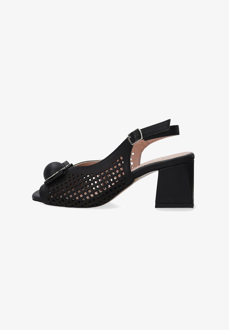 Black open-toe slingback shoe with a block heel, featuring a cutout grid design and a round accent on the front. Flat buckle closure.