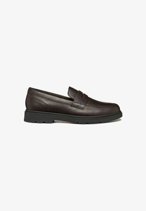 Mocassins en cuir marron avec une texture lisse, présentant un détail de vamp cousu et une semelle en caoutchouc noir durable. Design slip-on classique.