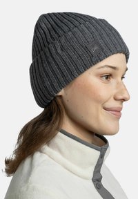 Gray ribbed knit beanie with a folded cuff and a logo patch. The fabric appears thick and textured, suitable for cold weather.
