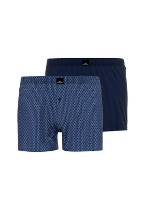 Twee paar herenboxershorts, één effen donkerblauw en één marineblauw met een klein wit ruitenpatroon, afgebeeld tegen een witte achtergrond.
