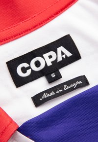 Clothing label on red, white, and blue fabric with brand name COPA, size S, and text saying Made in Europe in white on black tags.