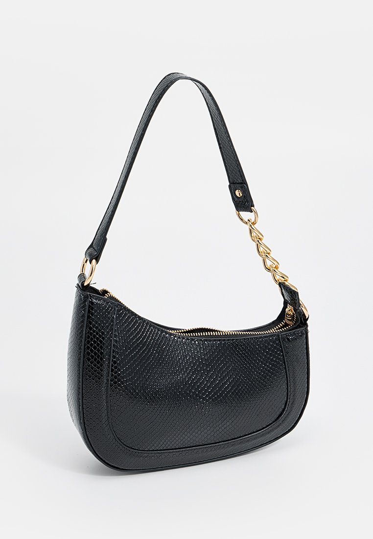 Sac à épaule noir texturé avec chaîne dorée et détails de fermeture éclair, en forme de rectangle incurvé, et poignée à simple sangle.