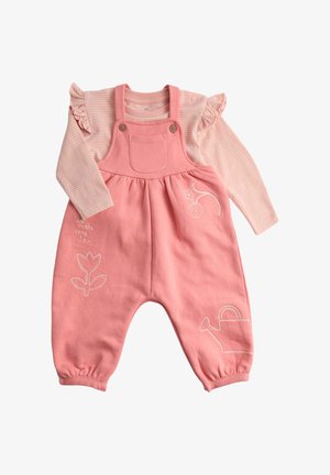 Růžové bavlněné kalhoty s nabíranou pruhovanou košilí s dlouhým rukávem pod nimi. Má vyšívané květiny, konev a přední kapsu.