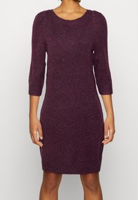 Abito in magenta, lavorato a maglia, con scollatura rotonda e maniche a trequarti. Design attillato con una texture morbida e orlo a costine.