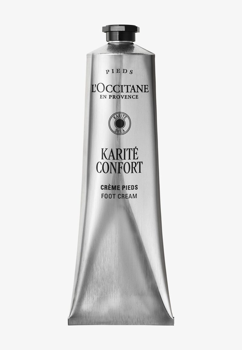 Aluminiumsrør fra L'Occitane Karité Confort fodcreme med sort låg og produktets branding i sort tekst på en ensfarvet baggrund.