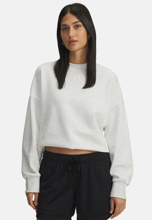 Light gray cropped sweatshirt with wide sleeves, textured fabric, and a small logo. Paired with black mesh athletic shorts featuring an elastic waistband.