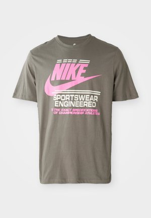Grå bomulds t-shirt med fremtrædende pink Nike branding og hvid tekst. Korte ærmer og rund halsudskæring.