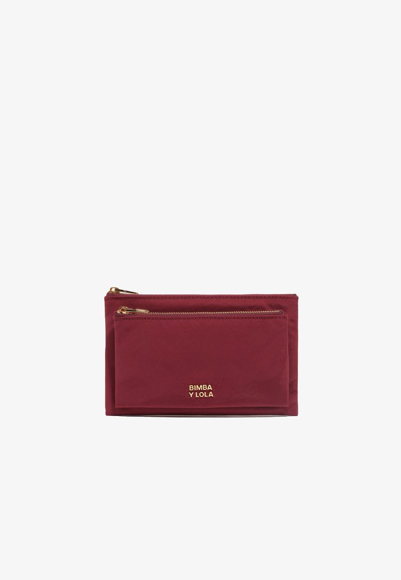 Funda de nailon burdeos con cremalleras en tono dorado, que presenta un bolsillo plano en la parte frontal y el logotipo de la marca en relieve en el frente. Textura suave.