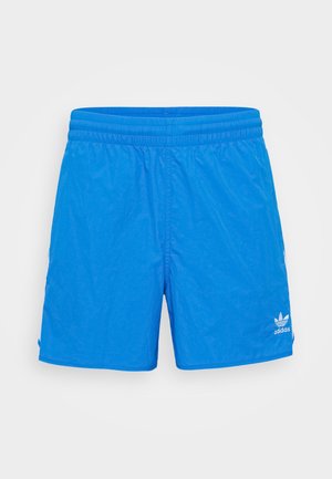 Helle blaue Adidas-Badeshorts mit elastischem Bund und weißem Logo am unteren linken Bein vor einfarbigem Hintergrund.