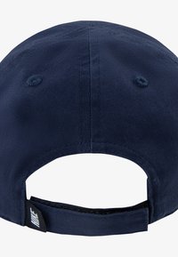 Tamno plava bejzbol kapa s zakrivljenim vizorom, izrađena od teksturiranog tkanja. Ima podesivu narukvicu i bijelu oznaku s logotipom na stražnjoj strani.