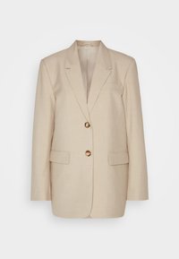 Μπεζ λινό σακάκι με πέτο, δύο μπροστινές τσέπες και κουμπιά με χρυσή απόχρωση. Διαθέτει κομψή, ψιλόλιγνη σιλουέτα.