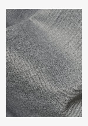 Hallikas kangas, millel on sile ja tekstureeritud viimistlus, millel on ühtlane kudumismuster, peegeldades valgust õrnalt üle oma pinna.