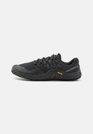 Zwarte sportieve schoen met een bovenwerk van mesh, een gestructureerde rubberen zool en veters. Heeft een vibramaccent op de hak voor extra grip en duurzaamheid.