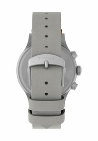 Montre à bracelet en silicone gris avec un boîtier en acier inoxydable, dotée de trois boutons latéraux et d'une fermeture à boucle sécurisée, embossée avec "TIMEX."