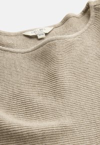 Beiger gerippter Strickpullover mit abgerundetem Halsausschnitt und Größenetikett "Cellbes of Sweden 38/40" auf weißem Hintergrund.