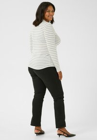 Striped long-sleeve top in light gray and white, paired with black slim-fit pants and black heeled sandals. Smooth texture, fitted silhouette.