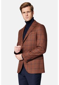 Brązowa marynarka w kratę z granatowymi akcentami, wykonana z teksturowanej tkaniny. Posiada klapę w kształcie notcha i zapięcie na pojedynczy guzik.