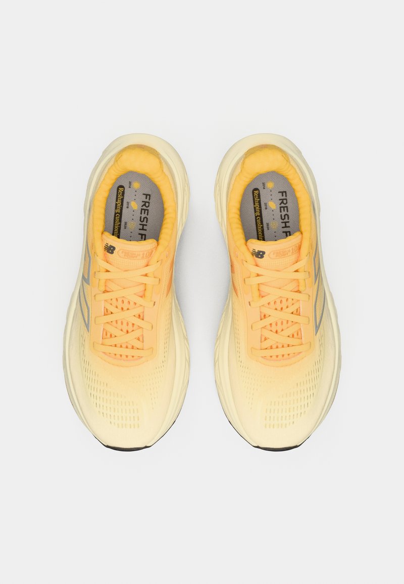 Un par de zapatillas de running New Balance amarillas con cordones, suelas de espuma y etiqueta de amortiguación "Fresh Foam" visible en el interior.