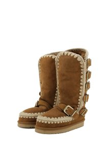 Stivali in suede marrone con design fino al ginocchio, fodera in pelliccia di pecora, dettagli intrecciati e diverse fibbie laterali.