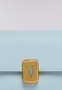 Svetlomodrá texturovaná kožená kabelka na ruku se zlatým obdélníkovým zapínáním s výřezovými vzory. Hladký povrch a jemný lesk.