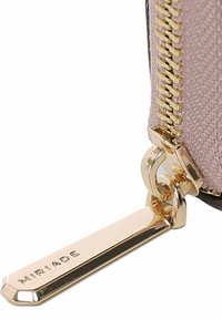 Zipperportemonnee van zachtroze stof met gouden hardware. Voorzien van een metalen ritssluiting met gegraveerde merknaam. Gestructureerde afwerking, rechthoekige vorm.