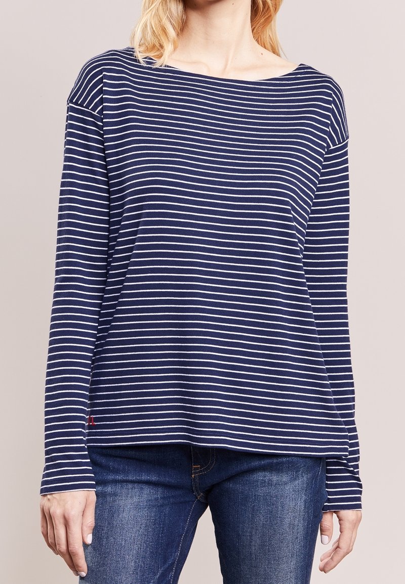 Marineblaues langärmliges Oberteil mit weißen horizontalen Streifen, aus weichem Stoff. Verfügt über einen Bootsausschnitt und leicht fallende Schultern.