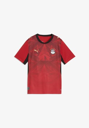 Maillot de football rouge à manches courtes avec col noir, motif géométrique pyramidal, logo Puma et écusson de l'Association égyptienne de football avec des étoiles.