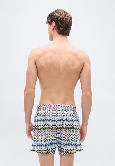 Shorts de bain colorés à motif zigzag, fabriqués en tissu léger, dotés d'une ceinture élastique et d'une coupe décontractée.