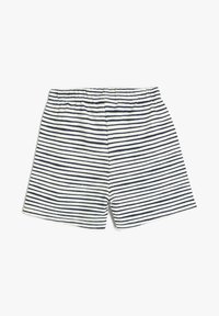 Hvide og marineblå stribede shorts med elastisk talje liggende fladt på en hvid baggrund.