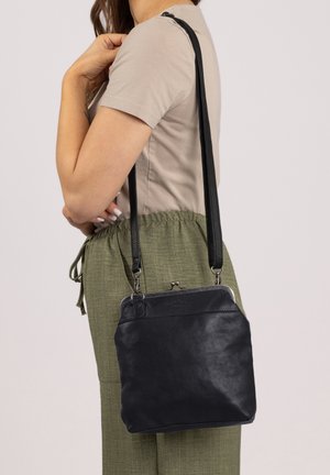 Black leather crossbody bag with a structured design, silver hardware, and a clasp closure. Features adjustable straps and a smooth texture.