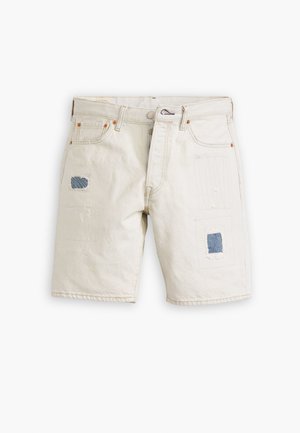 Beige denim shorts met patchwork details, voorzien van blauwe stofpatches, subtiele stiksels aan de voorkant en een klassieke vijfzakkenontwerp.