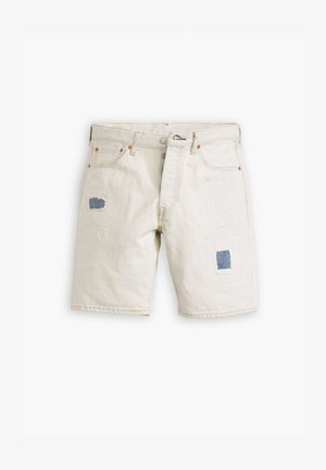 Pantalones cortos de mezclilla beige con detalles de patchwork, que presentan parches de tela azul, costuras sutiles en la parte frontal y un clásico diseño de cinco bolsillos.