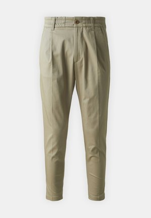 Light beige tapered trousers with an elastic waistband, front button closure, and two side pockets; smooth fabric with a slight sheen.